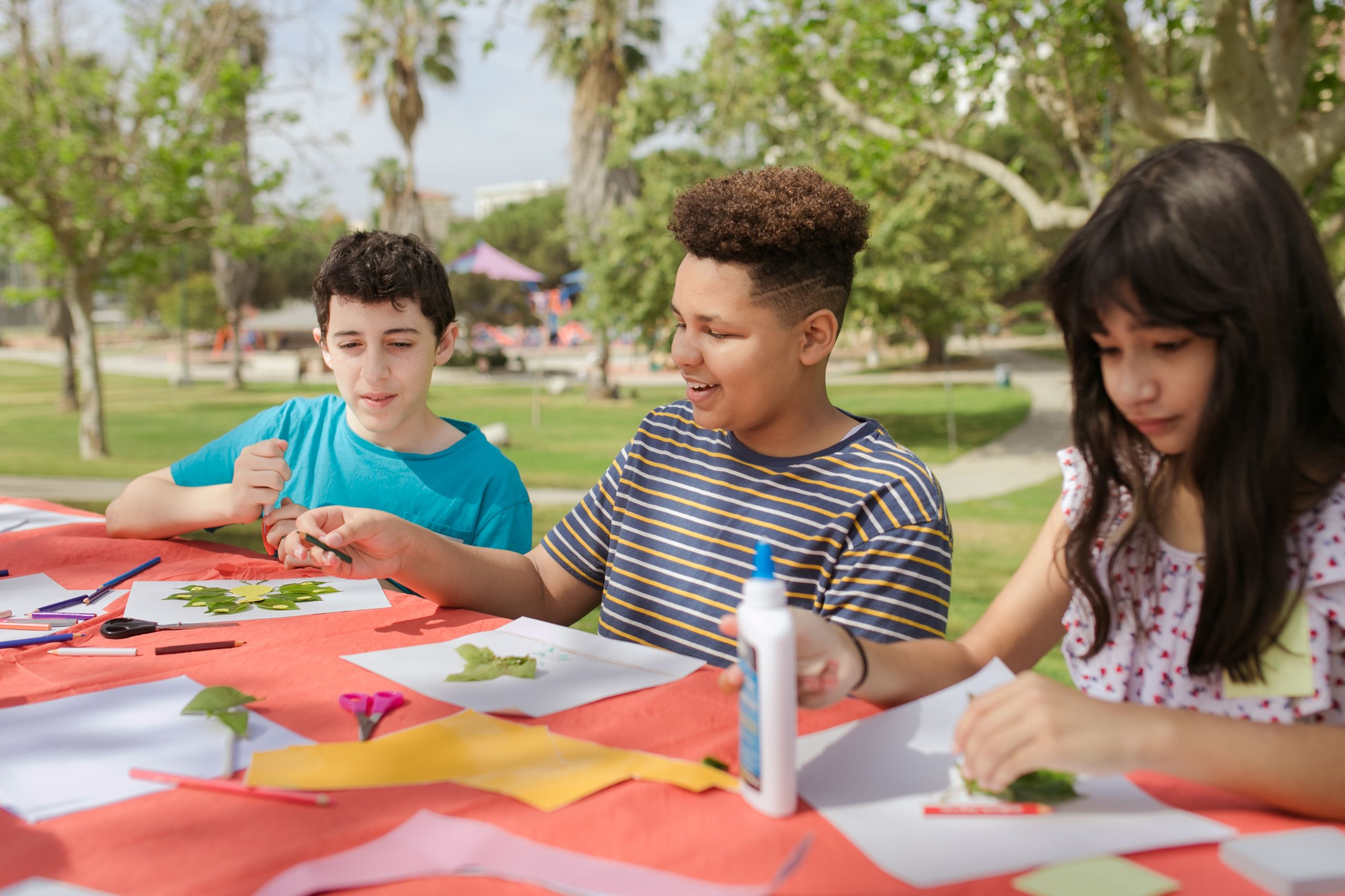 Kids creating art projects at an outdoor summer camp.